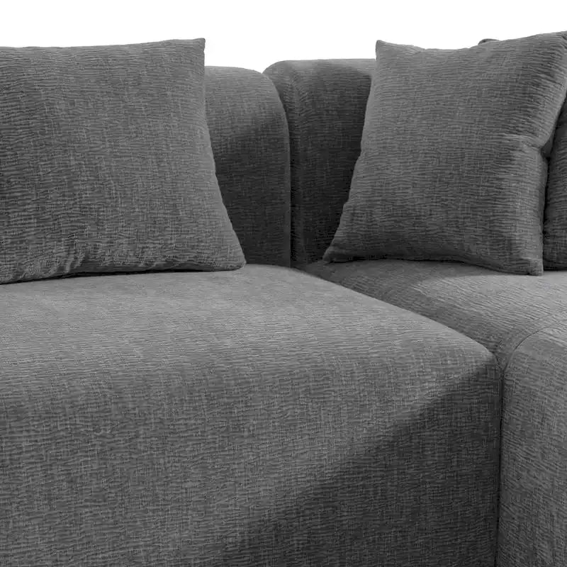 Canapé d'angle quatre places en polyester au design incurvé et surpiqûres larges.